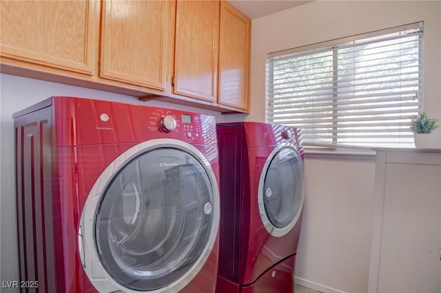 clothes washing area featuring cabinet space and separate washer and dryer