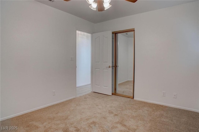 empty room featuring light carpet, baseboards, and a ceiling fan