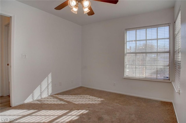 carpeted spare room with a ceiling fan, a healthy amount of sunlight, and baseboards