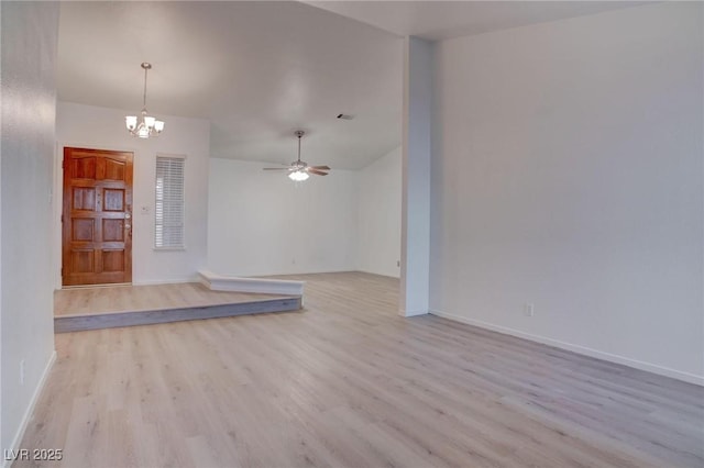 empty room featuring ceiling fan with notable chandelier, light wood finished floors, visible vents, and baseboards