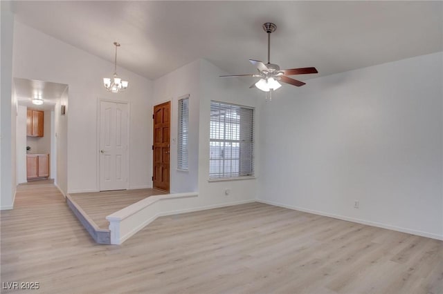 foyer featuring ceiling fan with notable chandelier, high vaulted ceiling, light wood-style flooring, and baseboards