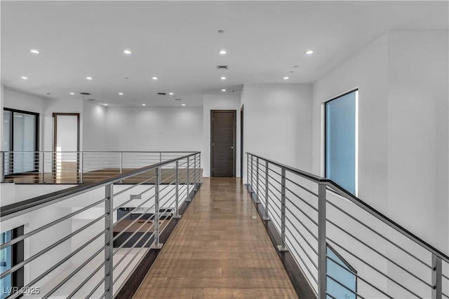 hallway with visible vents, dark wood-style flooring, an upstairs landing, and recessed lighting