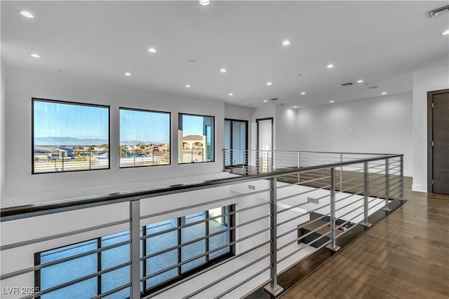 corridor featuring recessed lighting, visible vents, an upstairs landing, wood finished floors, and baseboards