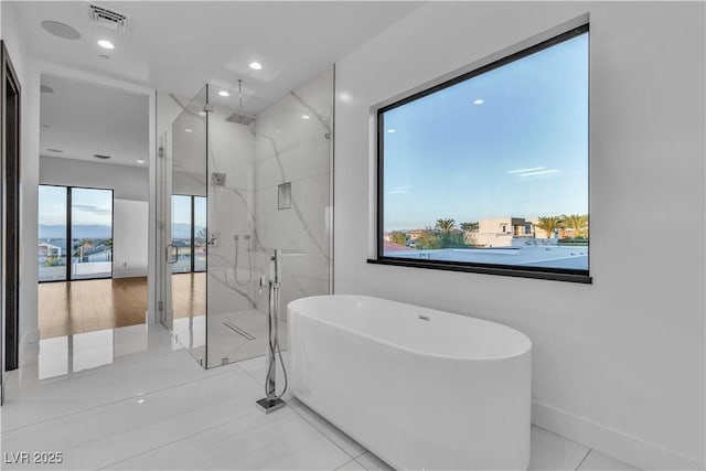 bathroom featuring a marble finish shower, recessed lighting, visible vents, a freestanding tub, and baseboards