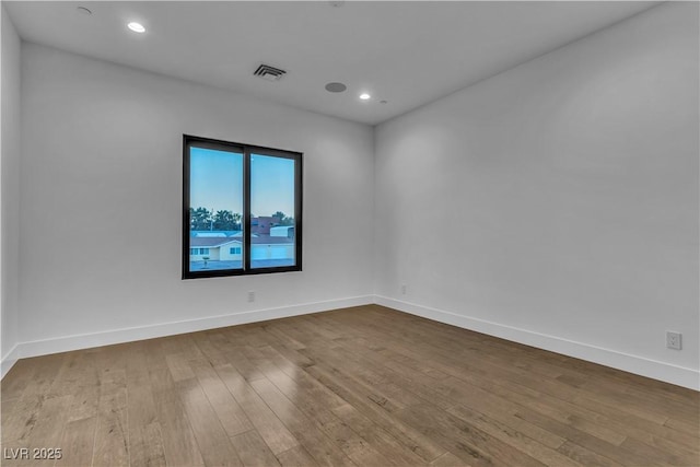 unfurnished room featuring dark wood-style floors, baseboards, and visible vents