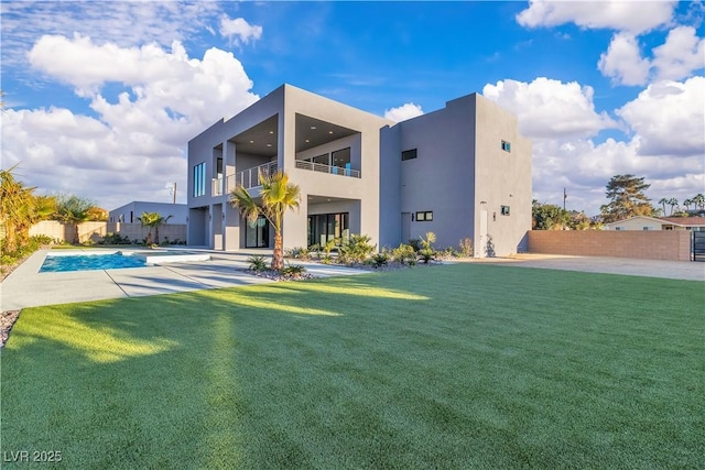 back of house featuring a fenced in pool, a balcony, fence, a yard, and stucco siding