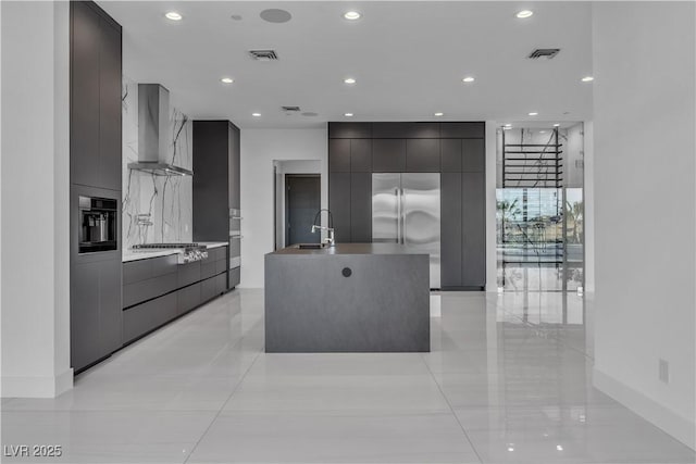 kitchen featuring stainless steel appliances, visible vents, wall chimney range hood, and modern cabinets