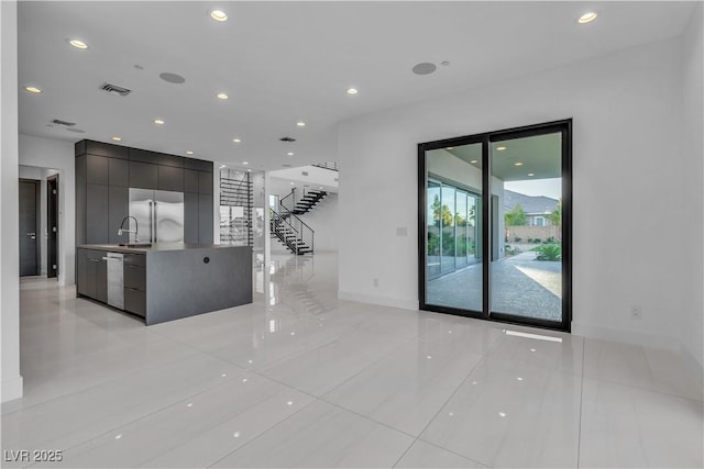 interior space featuring recessed lighting, visible vents, a sink, baseboards, and stairs