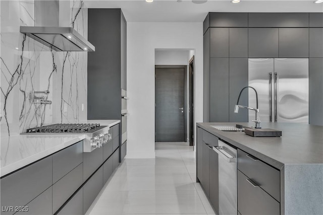 kitchen with wall chimney exhaust hood, appliances with stainless steel finishes, modern cabinets, and gray cabinets