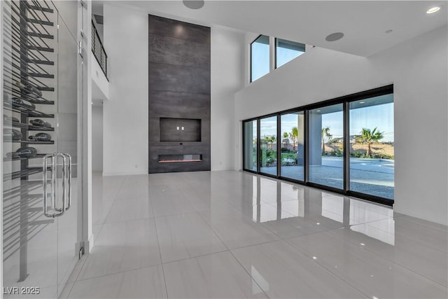2827 Richmar Ave, Henderson, NV 89074 - unfurnished living room featuring a high ceiling, tile patterned floors, and a fireplace