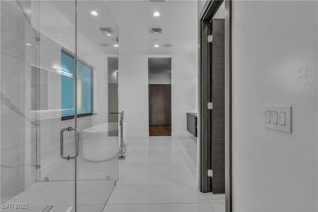 bathroom featuring a stall shower, a soaking tub, visible vents, and vanity