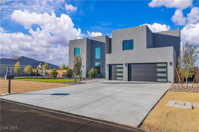 modern home with driveway, a garage, and stucco siding