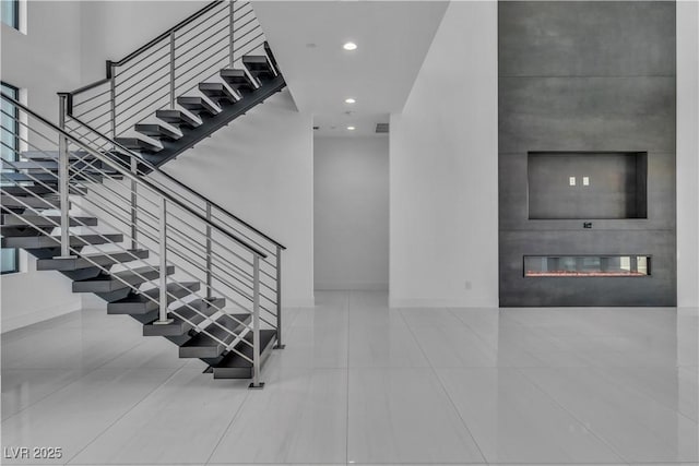 stairs featuring a fireplace, recessed lighting, visible vents, tile patterned flooring, and baseboards