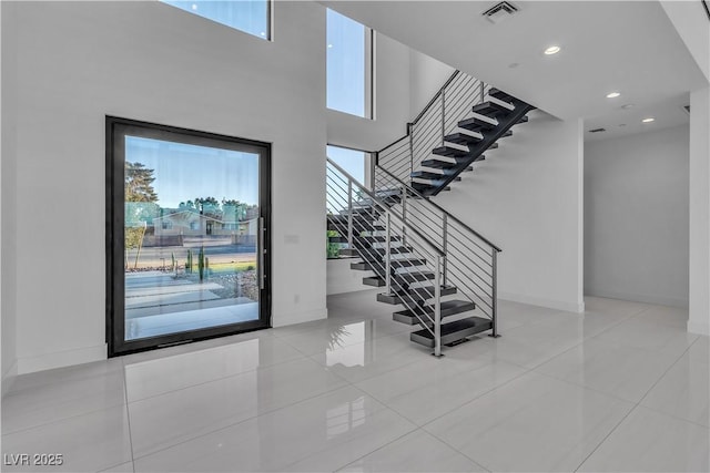 tiled foyer featuring recessed lighting, a healthy amount of sunlight, visible vents, and baseboards