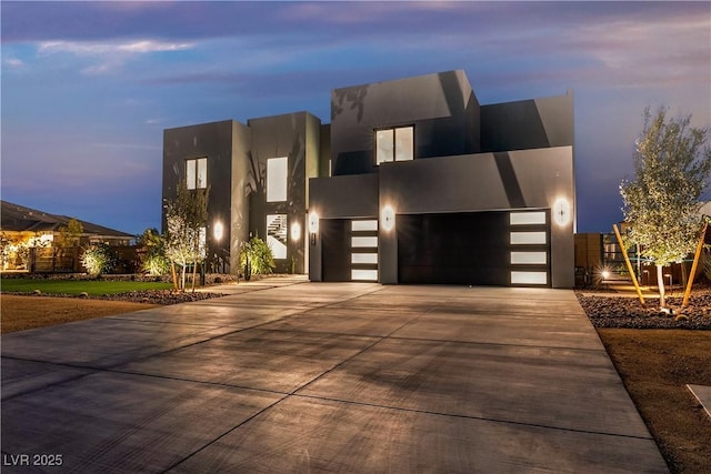 contemporary home featuring a garage, concrete driveway, and stucco siding