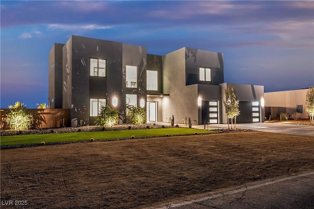 exterior space featuring driveway, a yard, and stucco siding