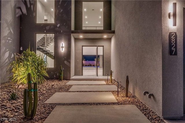 doorway to property featuring stucco siding