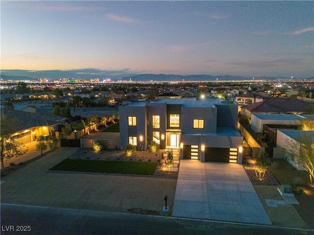 contemporary home with concrete driveway, fence, and stucco siding