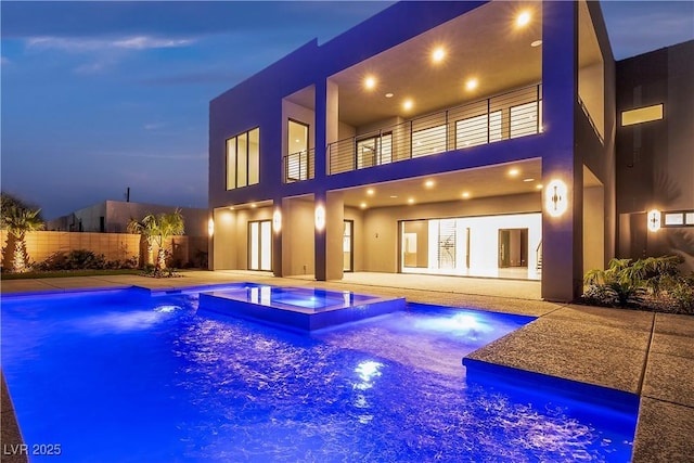 2827 Richmar Ave, Henderson, NV 89074 - back of property with a pool with connected hot tub, a patio area, stucco siding, fence, and a balcony