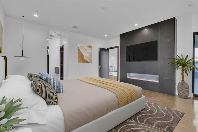 2827 Richmar Ave, Henderson, NV 89074 - bedroom with wood finished floors, recessed lighting, and a tile fireplace