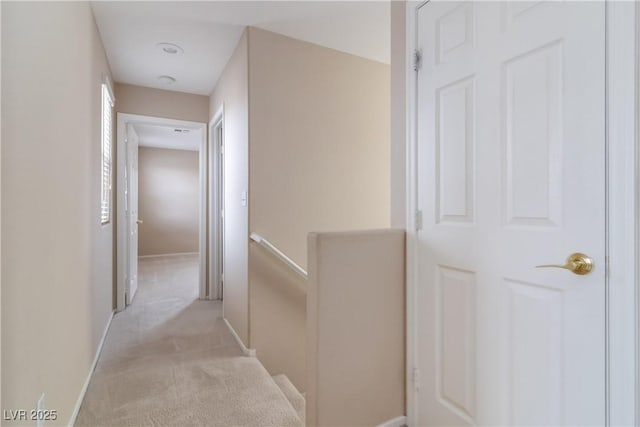 hallway featuring carpet and baseboards