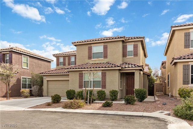 mediterranean / spanish home with a garage, concrete driveway, a tile roof, and stucco siding