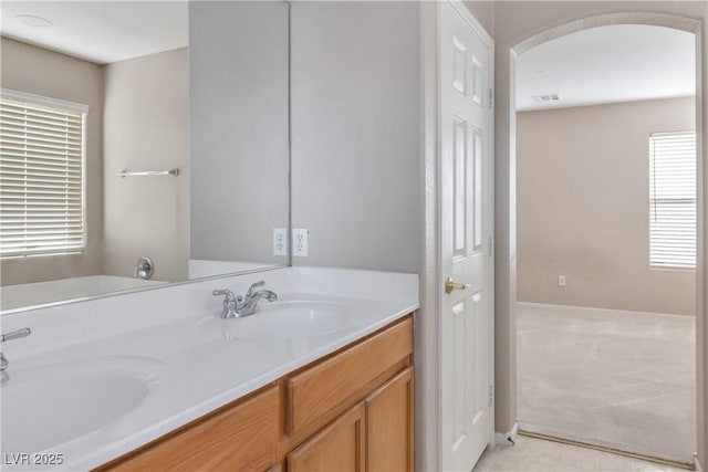 bathroom featuring visible vents, a sink, and double vanity