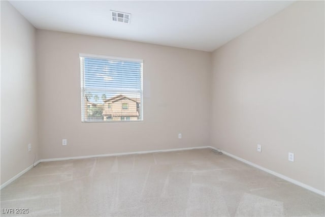 empty room featuring light carpet, visible vents, and baseboards