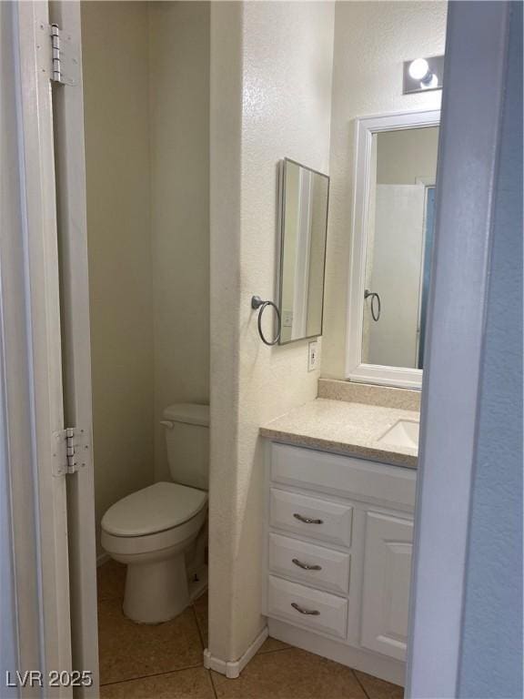 bathroom featuring toilet, vanity, and tile patterned floors