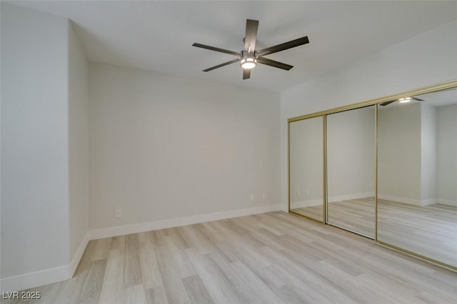 unfurnished bedroom featuring a closet, wood finished floors, and baseboards