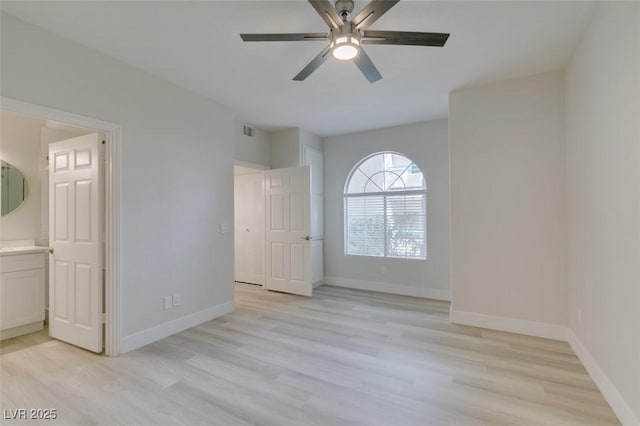 unfurnished bedroom featuring a ceiling fan, visible vents, baseboards, light wood-type flooring, and ensuite bath