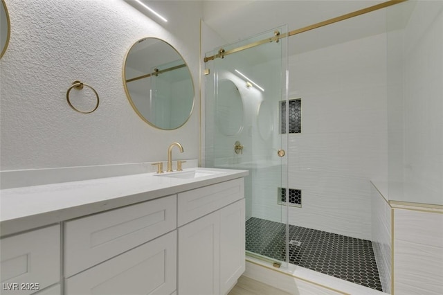 full bath with a shower stall and vanity