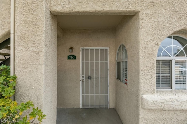 view of exterior entry featuring stucco siding