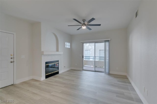 unfurnished living room featuring light wood-style floors, a fireplace, and baseboards