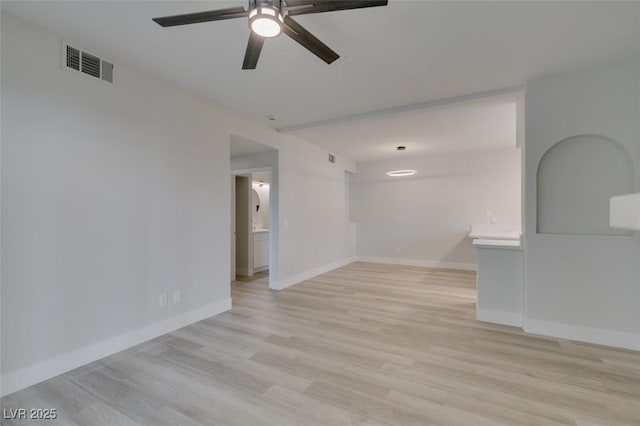 unfurnished room featuring light wood finished floors, baseboards, visible vents, and a ceiling fan