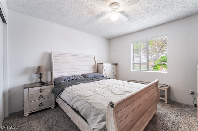 bedroom featuring dark carpet, ceiling fan, and a textured ceiling