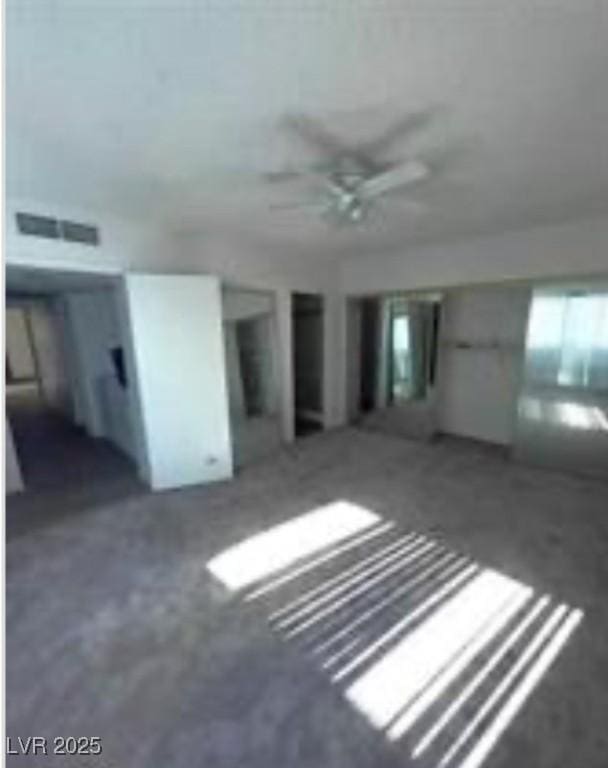 interior space with a ceiling fan, visible vents, and concrete flooring