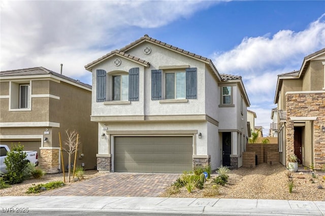 view of front of property featuring decorative driveway, an attached garage, a tile roof, and stucco siding