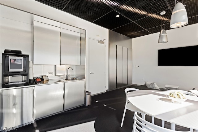 kitchen with white cabinetry, pendant lighting, a sink, and refrigerator