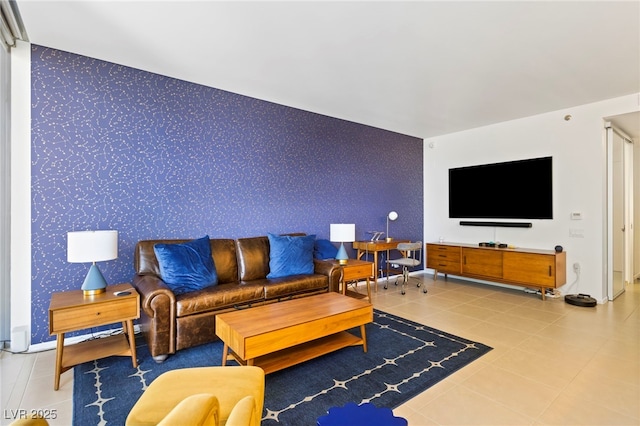 living area featuring an accent wall, tile patterned floors, and wallpapered walls