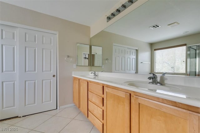 full bathroom with double vanity, tile patterned flooring, visible vents, and a sink