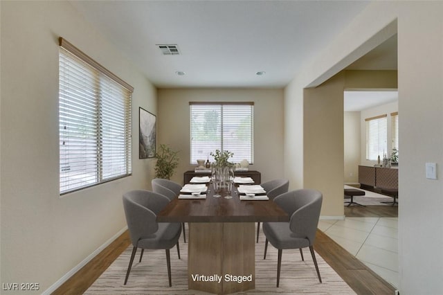 tiled dining room featuring baseboards and visible vents