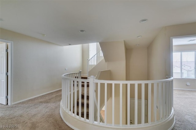 hall featuring carpet floors, an upstairs landing, baseboards, and recessed lighting