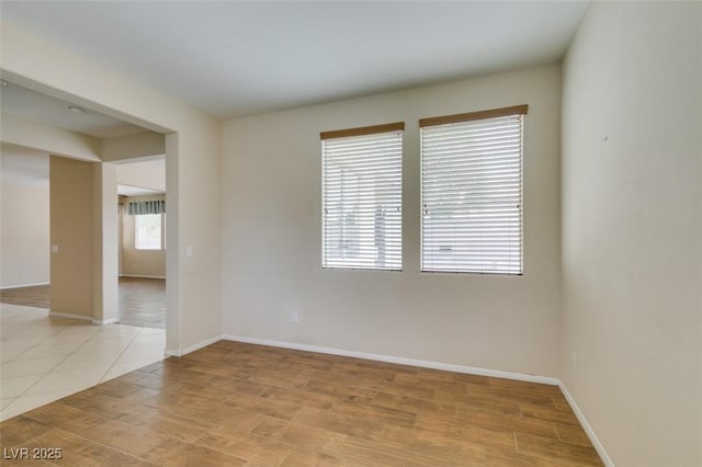 spare room featuring light wood-style flooring and baseboards