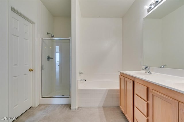 bathroom featuring a stall shower, a garden tub, a sink, and double vanity