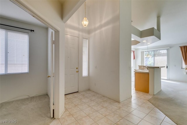 entrance foyer with light carpet and light tile patterned flooring