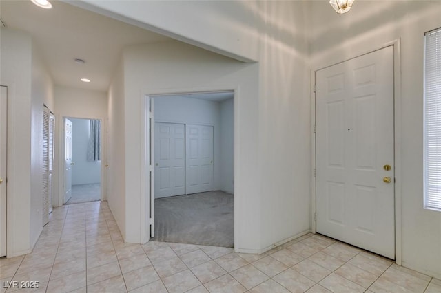 foyer with recessed lighting, light colored carpet, and light tile patterned floors