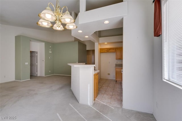 kitchen featuring light colored carpet, open floor plan, light countertops, a chandelier, and recessed lighting