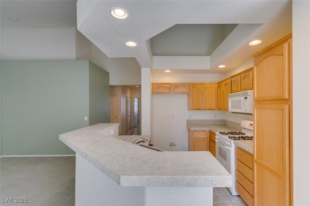 kitchen featuring light countertops, white appliances, light brown cabinets, and recessed lighting