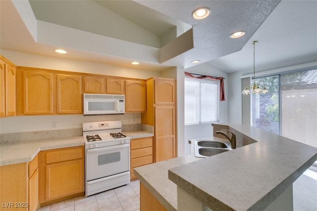 kitchen featuring white appliances, hanging light fixtures, light brown cabinetry, a sink, and recessed lighting